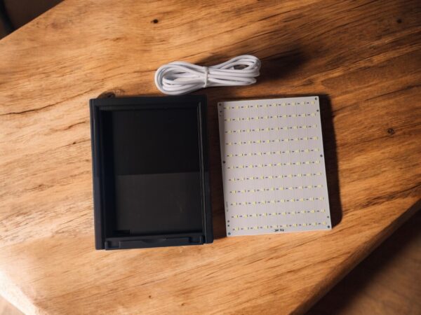 Ramka, płytka led i kabel na drewnie